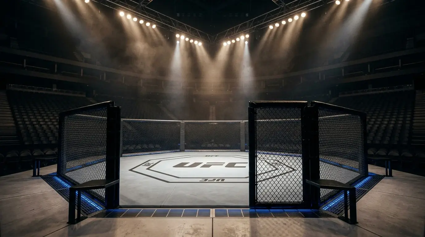 Empty UFC octagon inside a lit arena before a fight event with dramatic overhead spotlights